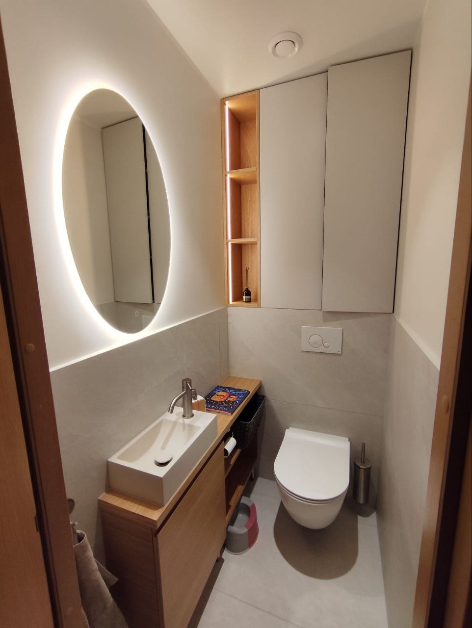 Renoveeritud WC valgustatud peegli ja seinale paigaldatud potiga